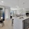 Spacious, open-concept kitchen and dining area with plank flooring, granite counters and large windows
