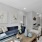 Living room with blue sofa and white side chair with wall art