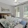 Bedroom with queen bed, wall art and two large windows with plantation shutters
