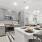 Spacious and well lit kitchen with wood floors and stainless steel appliances. 