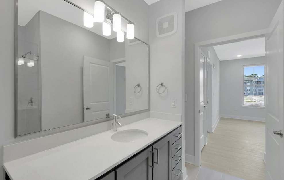 bathroom leading into a bedroom with bright lighting